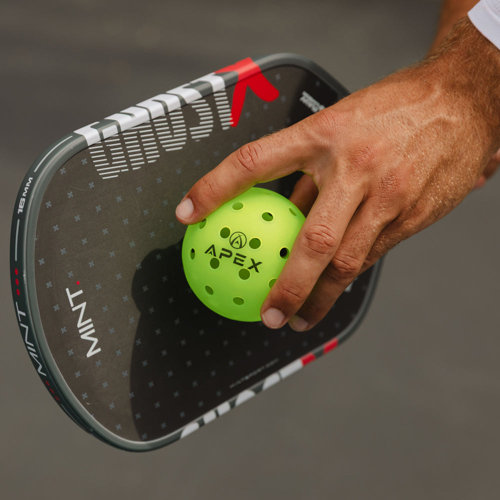 Player holding an APEX pickleball at their side